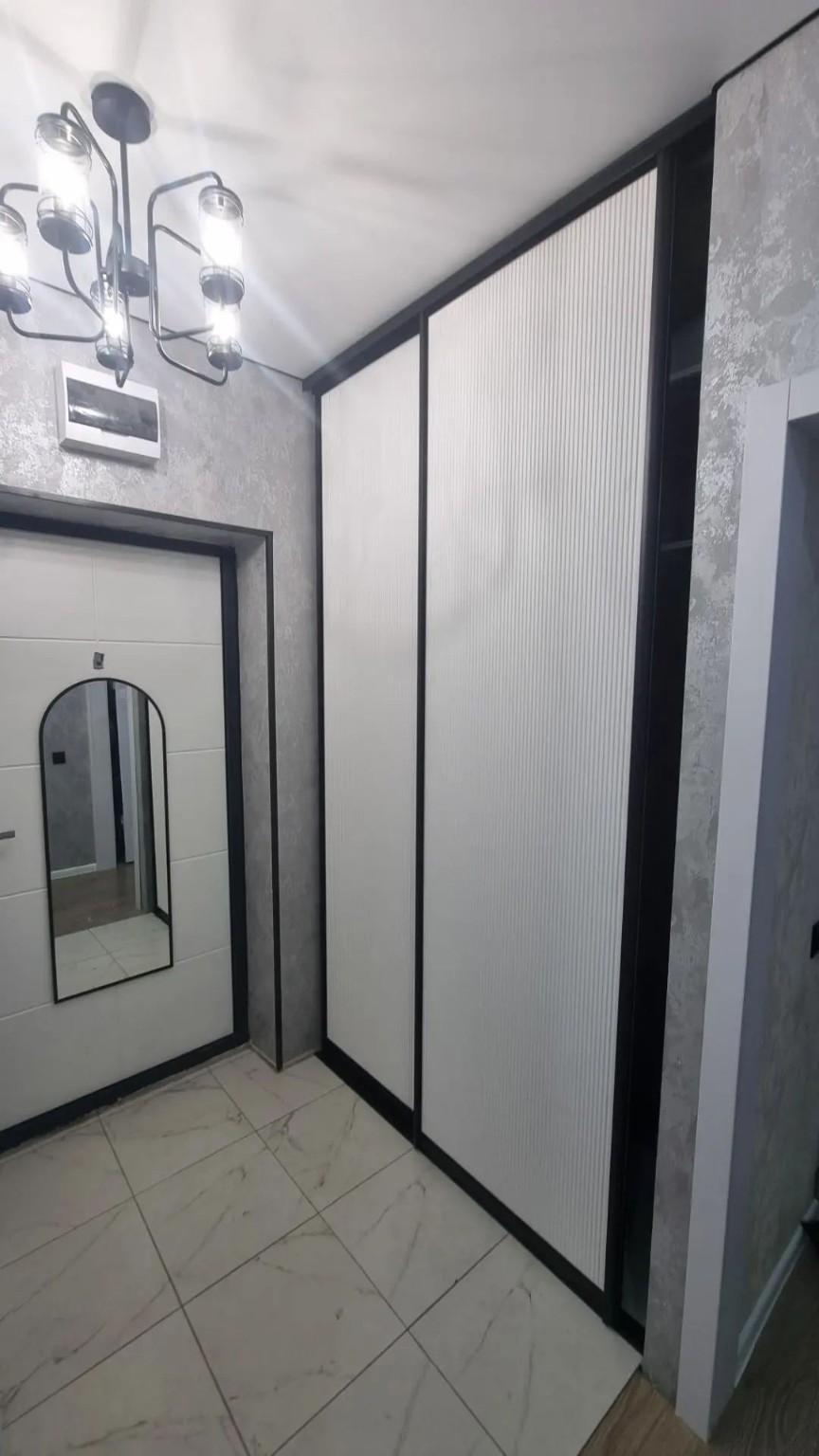 Шкаф с белыми рифлёными фасадами в чёрной рамке